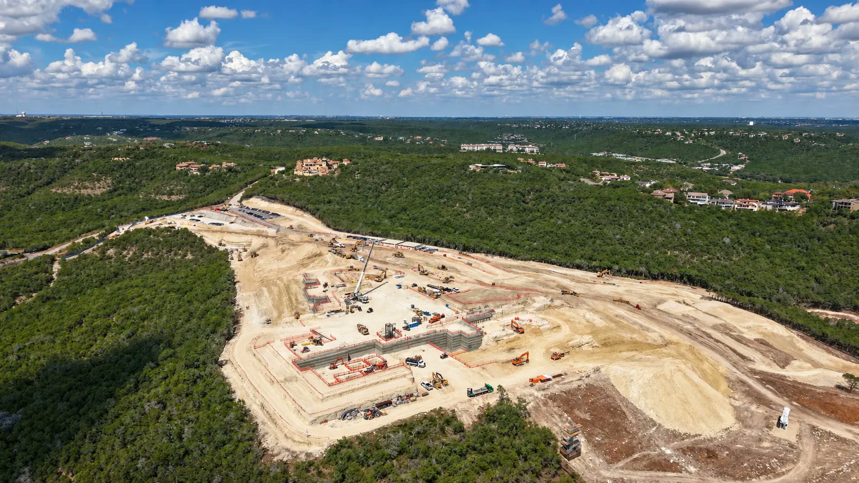Aerial view of the Four Seasons Private Residences Lake Austin construction site surrounded by Hill Country woodland.